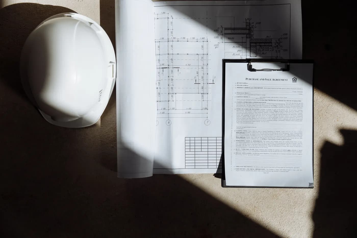 Documentos de contrato de obra con casco de seguridad